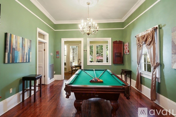 A pool table in a room with green walls.