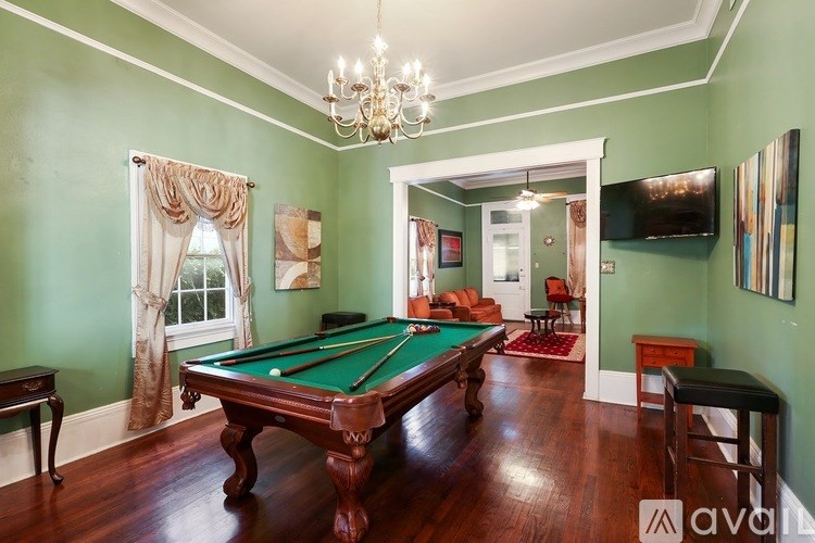A room with a pool table and a green wall.
