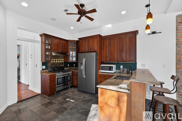 A kitchen with wooden cabinets and a tiled floor.