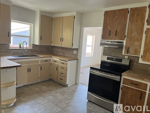 A kitchen with wooden cabinets and a black oven.