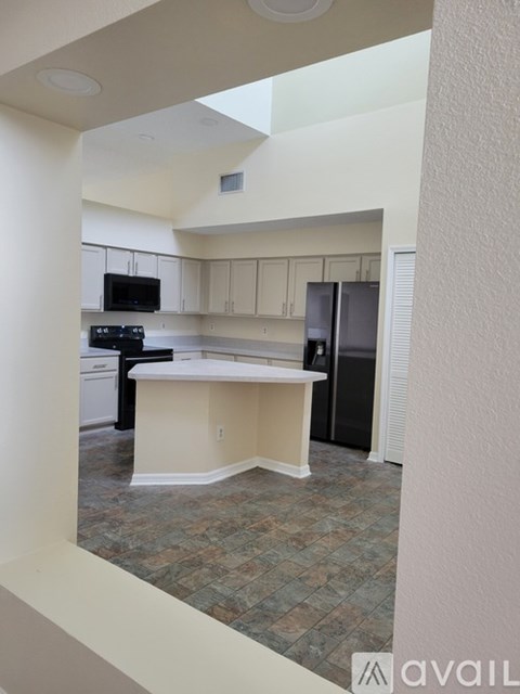 A kitchen with a black stove top oven and a black refrigerator.