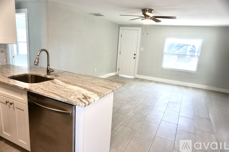 A kitchen with white cabinets and a stainless steel refrigerator.