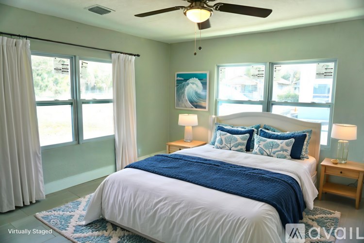 A bedroom with a large bed and a ceiling fan.