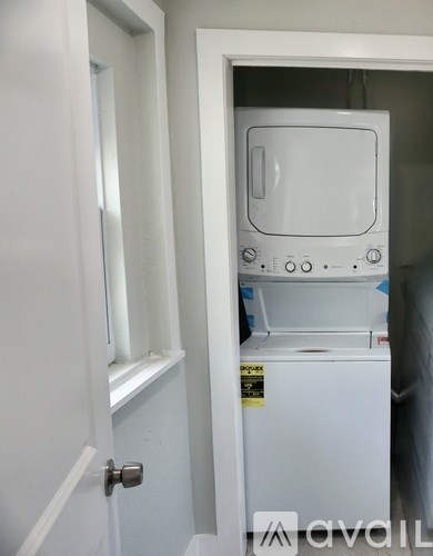 A white oven with a sticker on it is in a doorway.