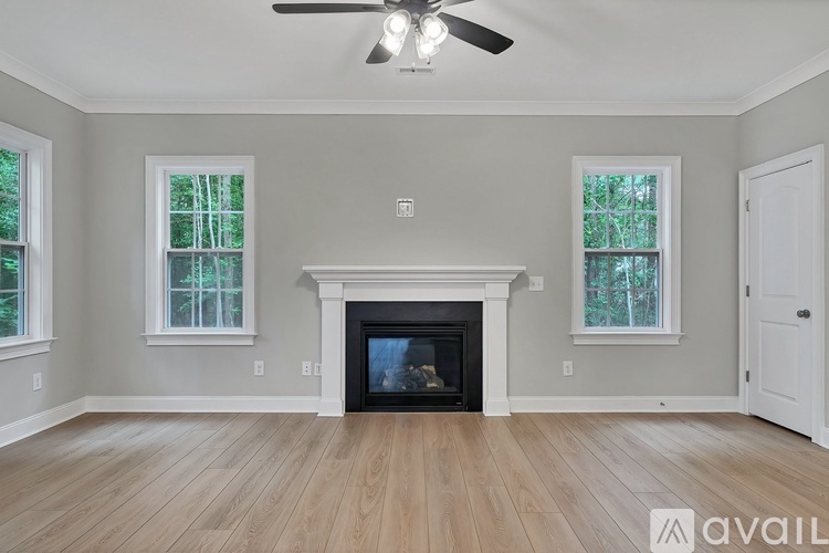 A living room with a fireplace and a ceiling fan.