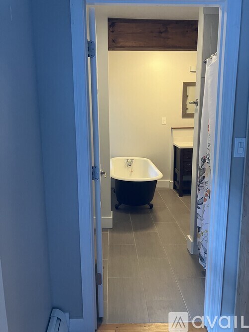 A bathroom with a tub and a toilet.