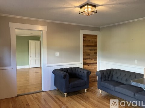A living room with two couches and a wooden accent wall.