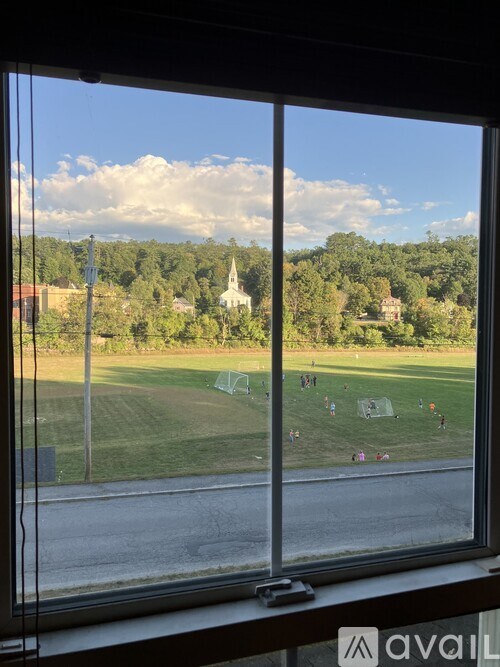A view from a window looking out at a soccer field.