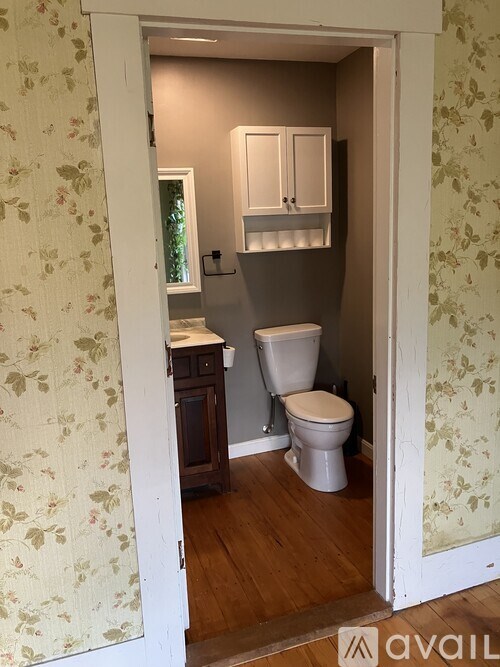 A bathroom with a toilet and a cabinet.