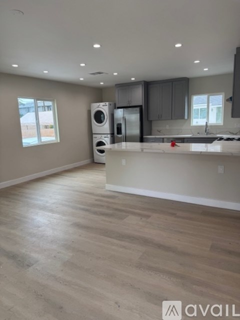 A kitchen with a washer and dryer stacked together.