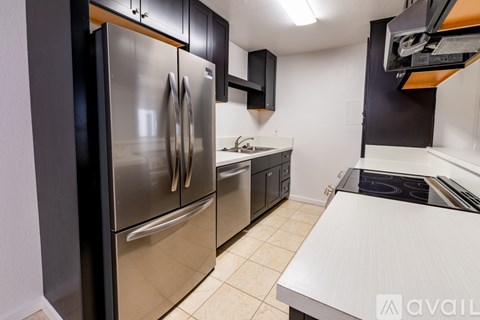 A modern kitchen with a stainless steel refrigerator and a white countertop.