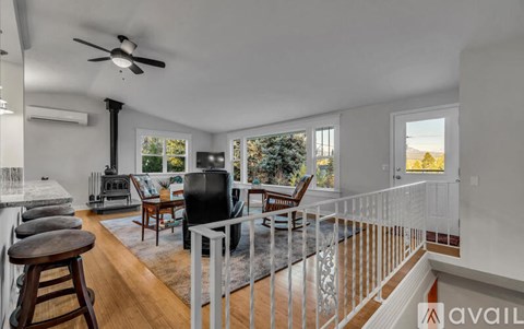 A living room with a black television and a glass railing.