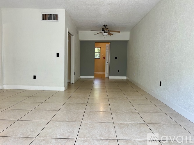 A spacious room with a ceiling fan and tiled flooring.