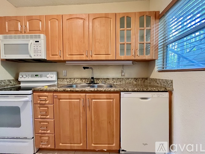 A kitchen with wooden cabinets and a granite countertop.