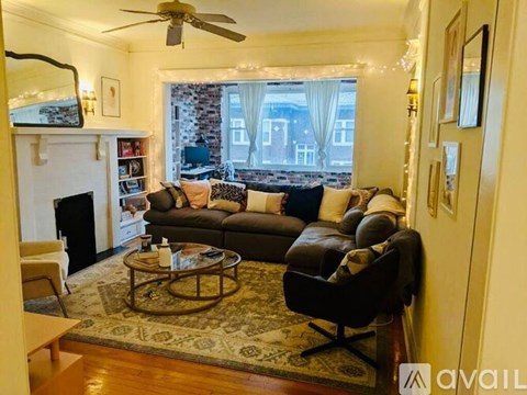 A living room with a fireplace and a large window.