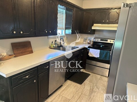 A kitchen with black cabinets and a white countertop.