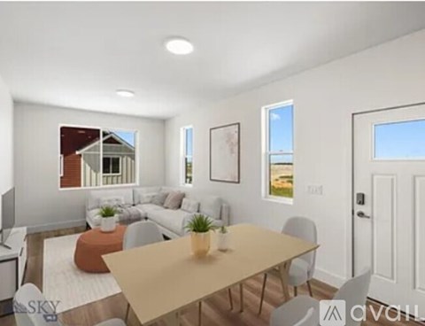 A modern living room with a dining table and chairs.