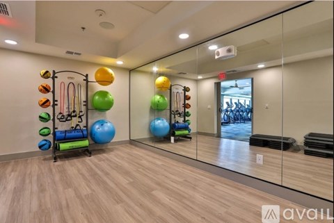 A gym room with exercise equipment and mirrors.