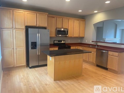 A kitchen with wooden cabinets and a black countertop.