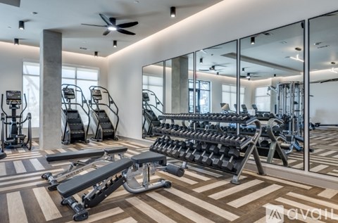 A gym with a variety of equipment including treadmills, weights, and a rowing machine.