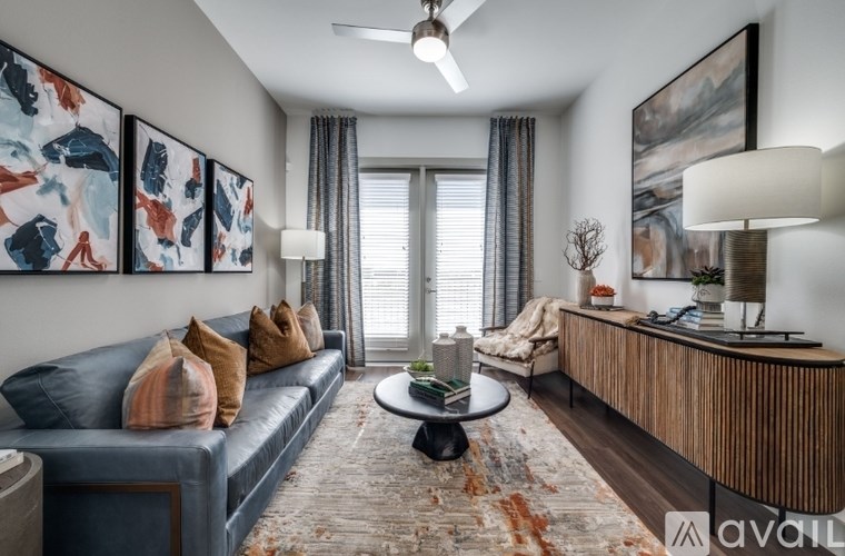 A living room with a blue couch, a coffee table, and a painting on the wall.