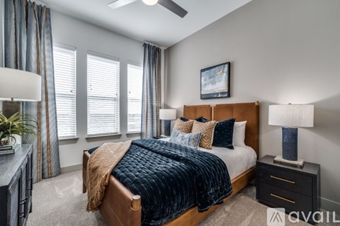 A bedroom with a large bed and a ceiling fan.