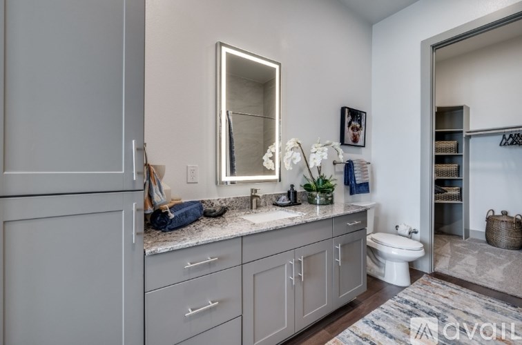 A bathroom with a vanity, toilet, and a mirror.