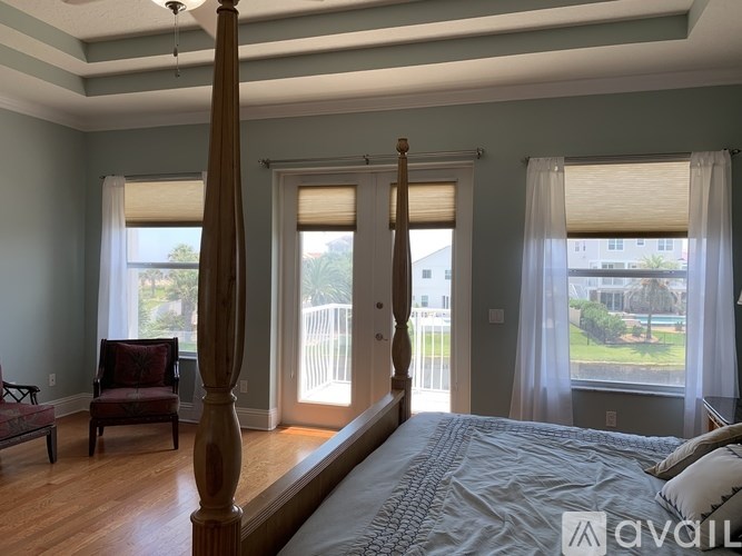 A bedroom with a large bed and a chair.