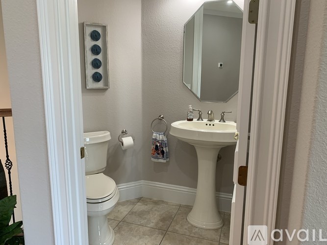A bathroom with a toilet, sink, and mirror.