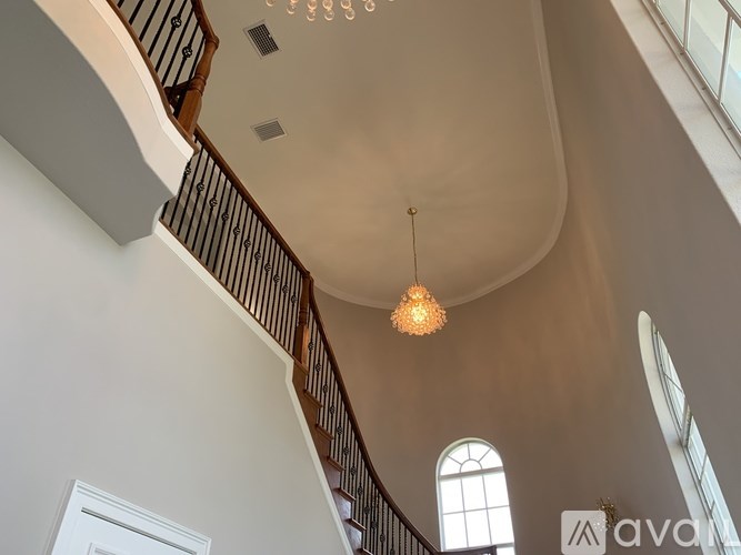 A large, well-lit room with a curved ceiling and a staircase.