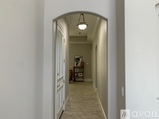 A hallway with a white door and a light on the ceiling.