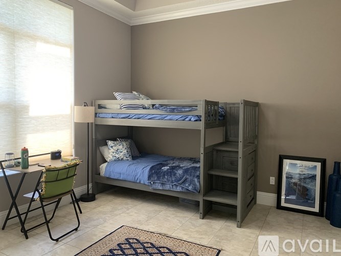 A bedroom with a bunk bed and a chair.