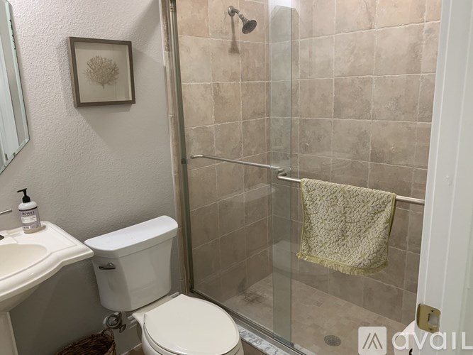 A bathroom with a toilet, sink, and shower.