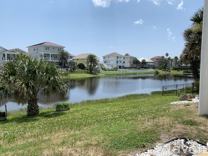 A row of houses with a body of water in front of them.