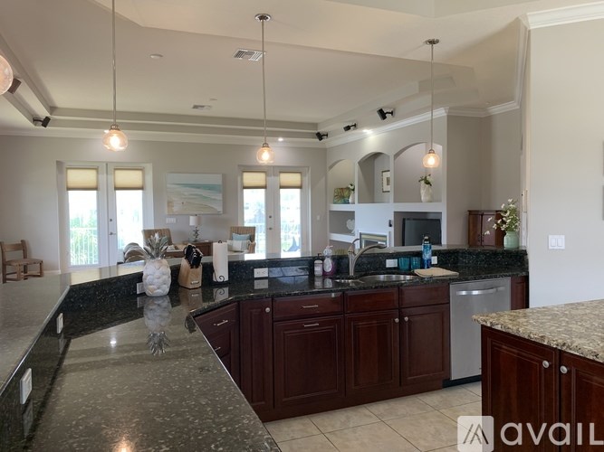 A kitchen with dark wood cabinets and granite countertops.