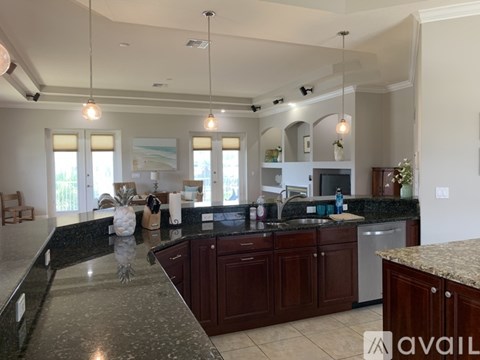 A kitchen with dark wood cabinets and granite countertops.