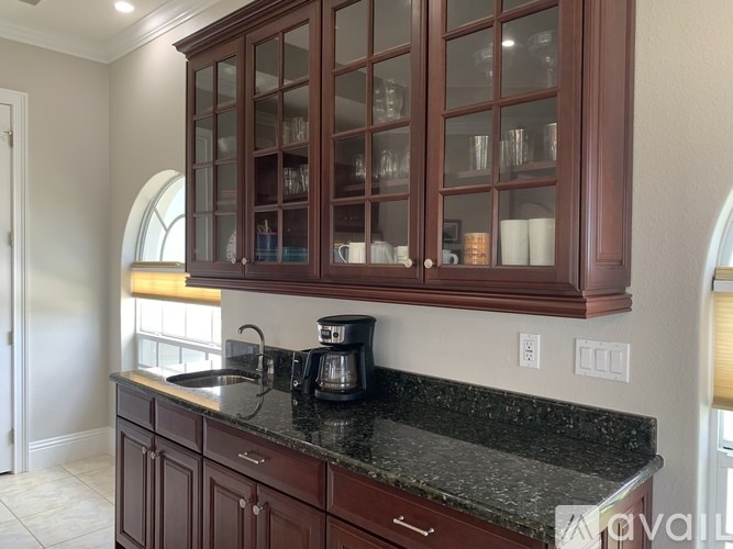 A kitchen with brown cabinets and granite countertops.