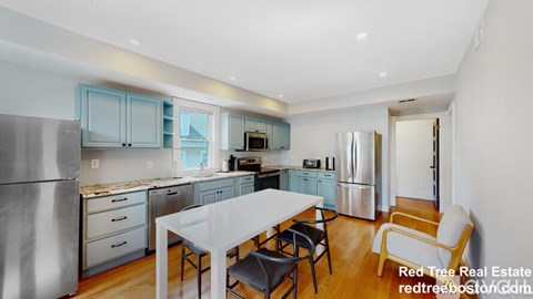 A modern kitchen with a dining table and chairs.