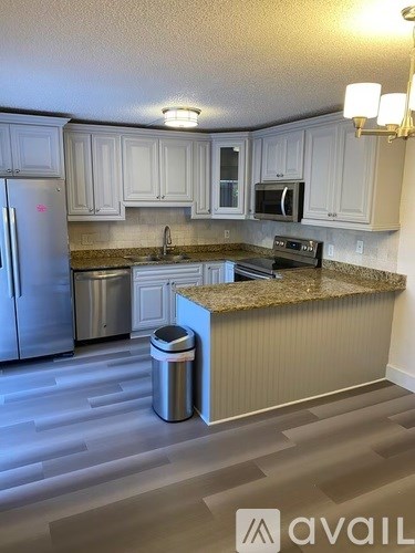 A kitchen with granite countertops and stainless steel appliances.
