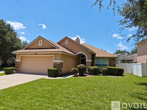 A house with a brown roof and a white fence.