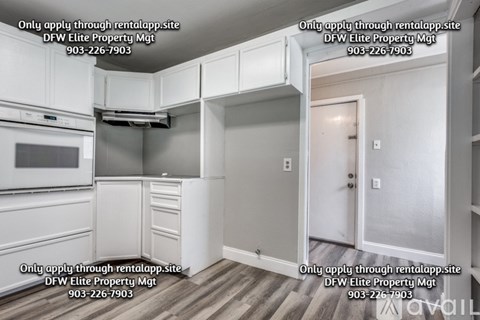 A kitchen with white cabinets and a white door.