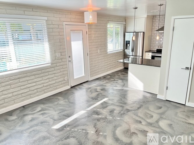 A kitchen with a marble floor and white cabinets.
