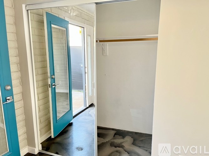 A room with a blue door and a white wall.