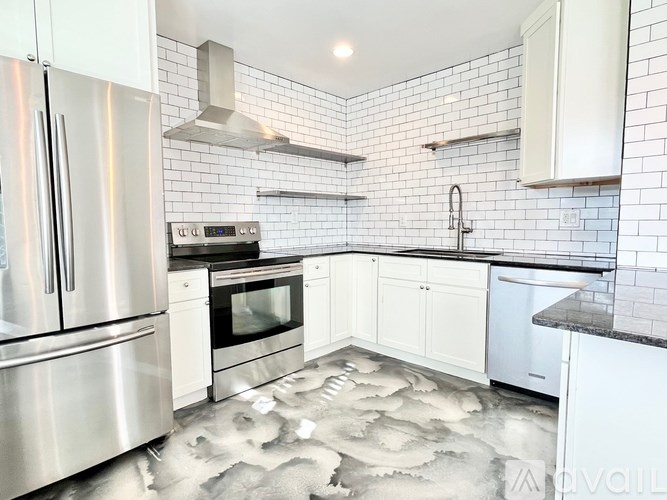 A modern kitchen with stainless steel appliances and white cabinets.