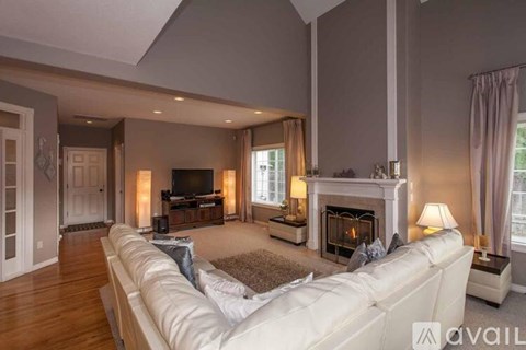 A living room with a white couch and a fireplace.