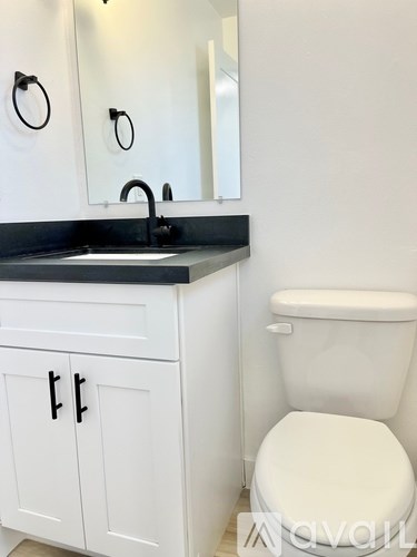 A white toilet sits next to a sink in a bathroom.