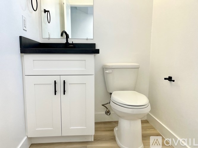 A white toilet sits next to a sink in a bathroom.