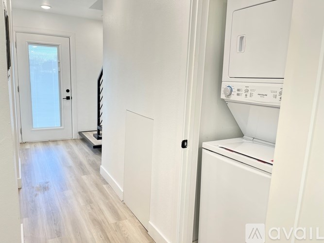 A white washing machine is installed in a laundry room.