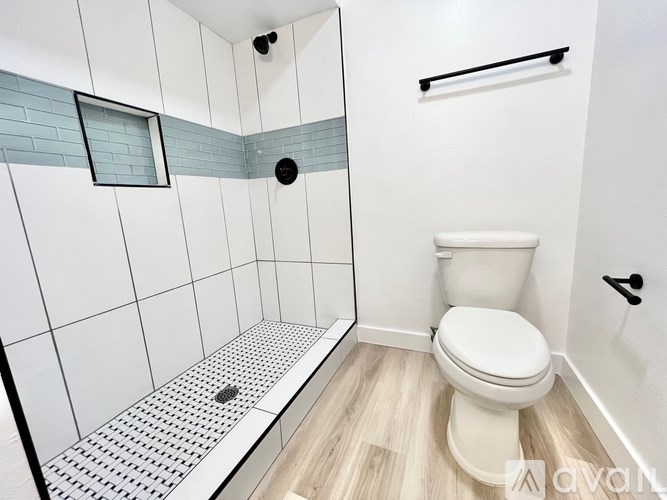 A white toilet in a bathroom with a shower.