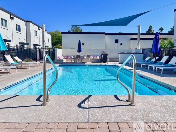 A swimming pool with a slide and sun loungers.